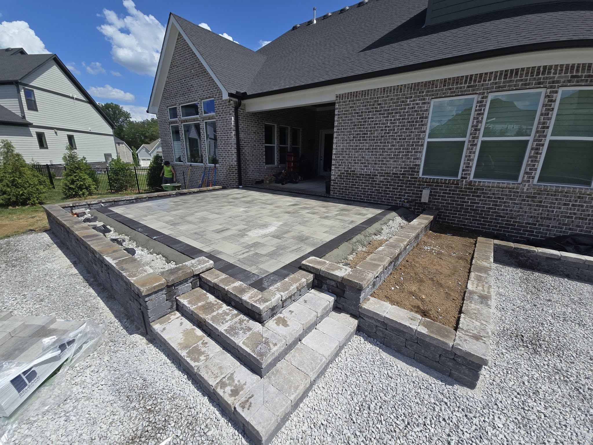 paver patio with surrounding stairs and flower beds